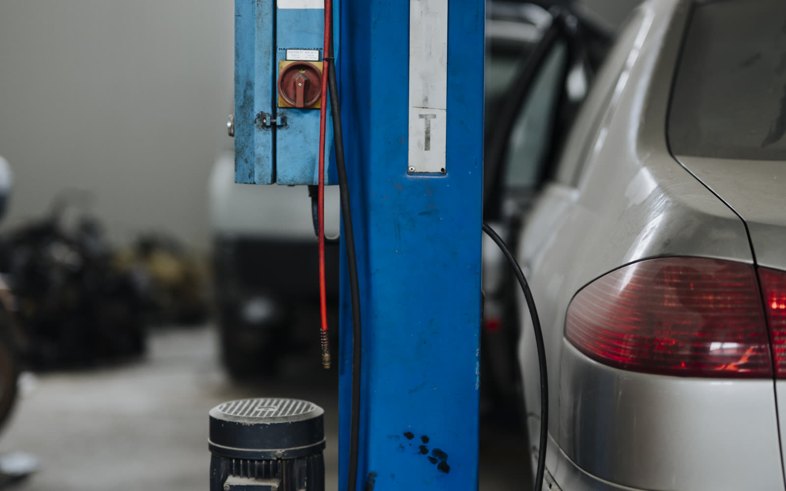 Oficina automotiva organizada com veículo elevado, representando atendimento, histórico do cliente e pós-venda